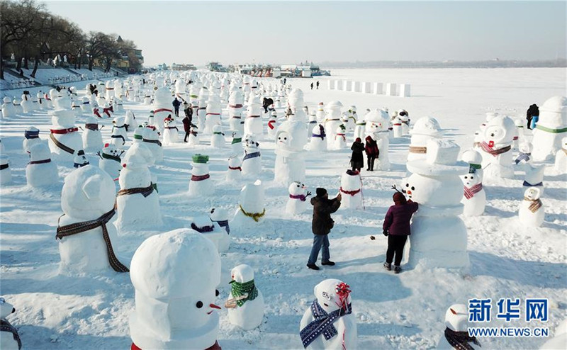 1月2日，市民、游客在雪人群中游玩觀賞（無人機拍攝）。2019個各式各樣的雪人，近日在冰城哈爾濱市的松花江畔亮相，引來眾多市民游客游玩觀賞。新華社記者 王建威 攝