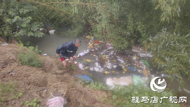 駐馬店經濟開發區賈莊居委會志愿者冒雨清理河道